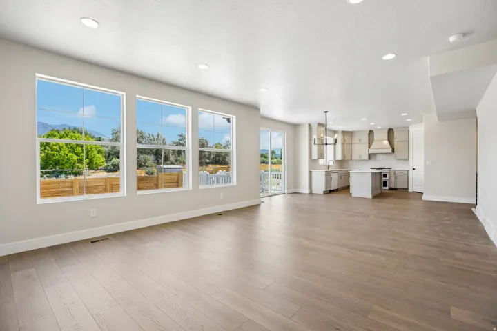 Open-concept living space featuring wood-finish flooring, recessed lighting, and a neutral color palette