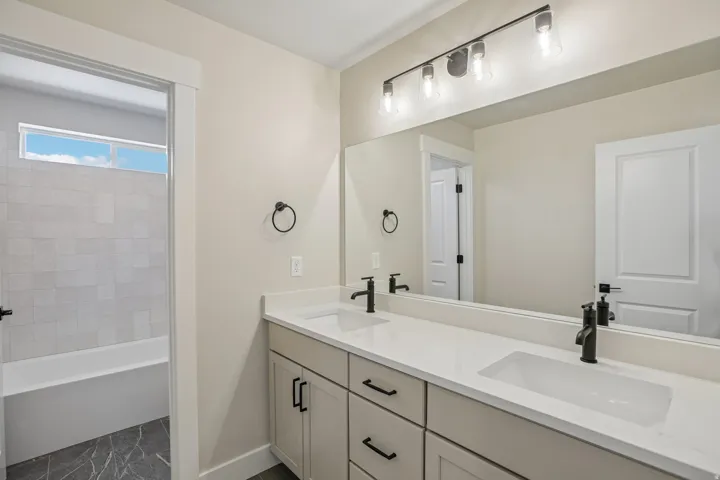 Double vanity with integrated sinks and white countertops, complemented by matte black fixtures