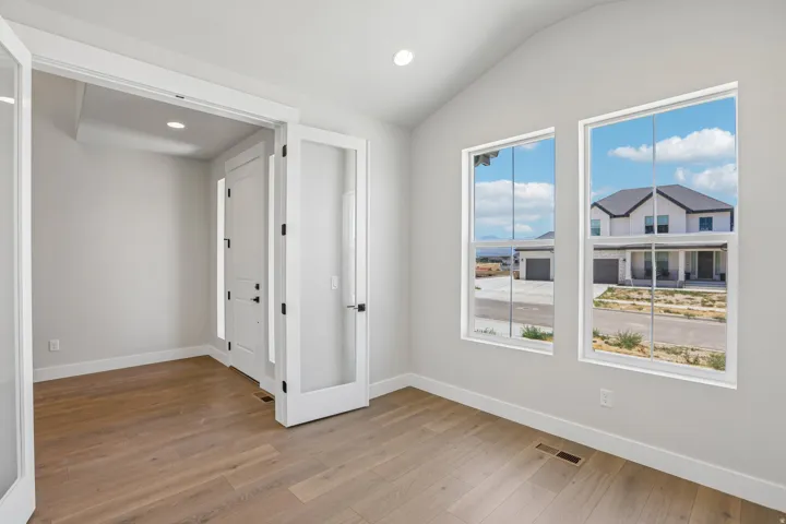 Room featuring wood-finish flooring, white baseboards, and light gray walls