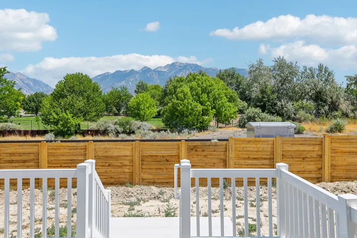 White deck railings overlooking a wooden privacy fence