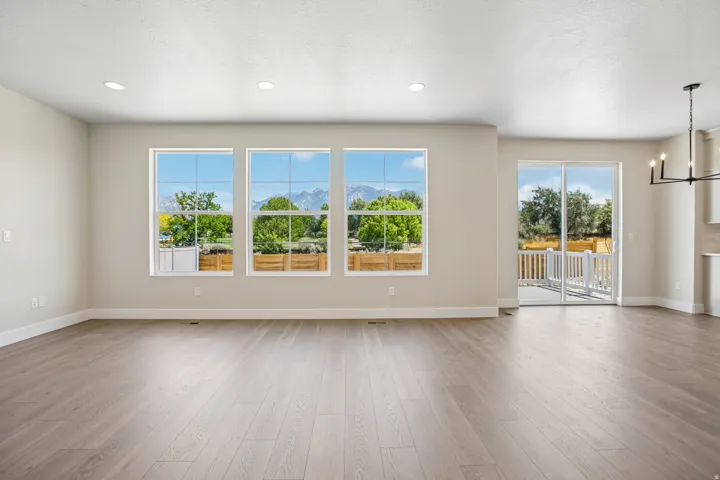 Expansive room featuring wood-finish flooring, recessed lighting, and a neutral wall color