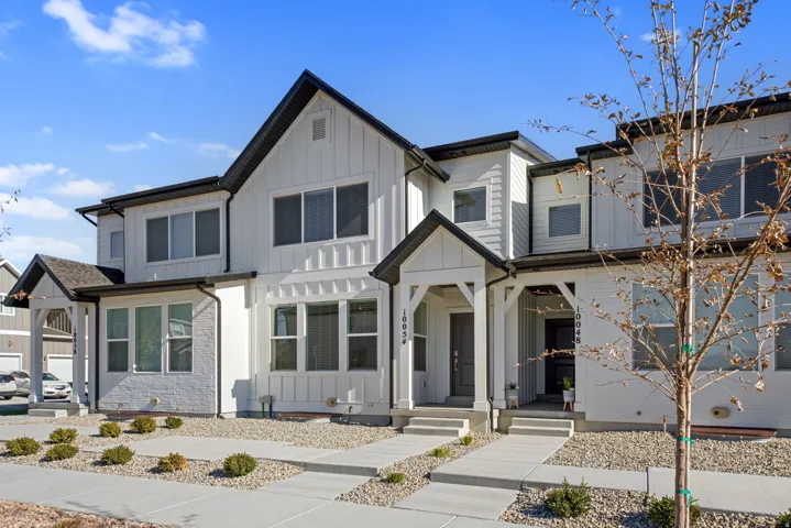 Modern townhome exterior featuring white siding and dark trim