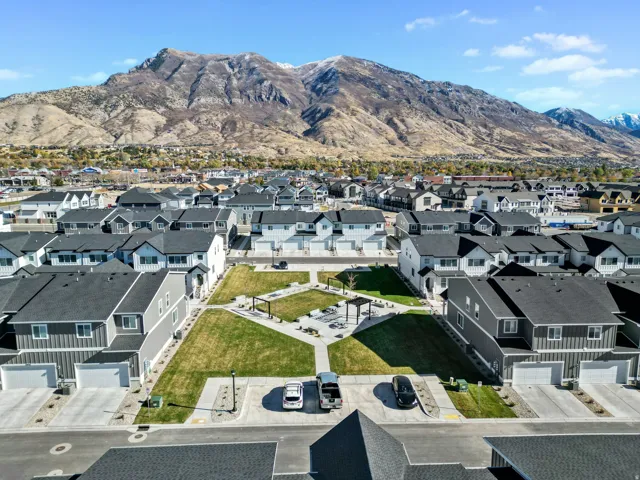 Newly constructed residential community featuring a central green space with walking paths and seating areas