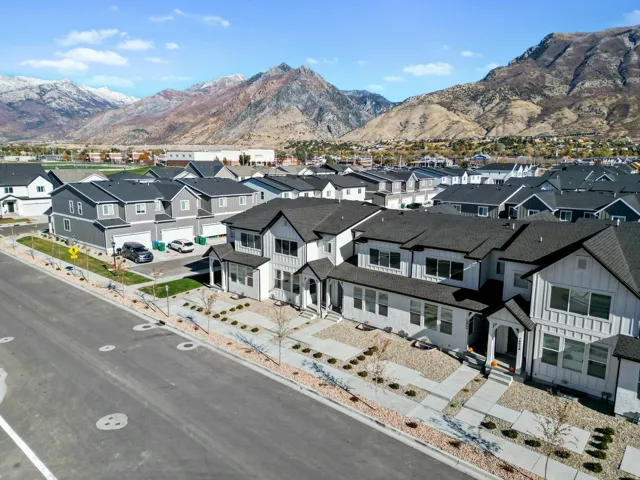 Modern residential development featuring a collection of homes with dark roofs and light-colored siding