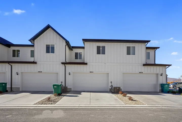 Contemporary townhome exterior featuring white vertical siding