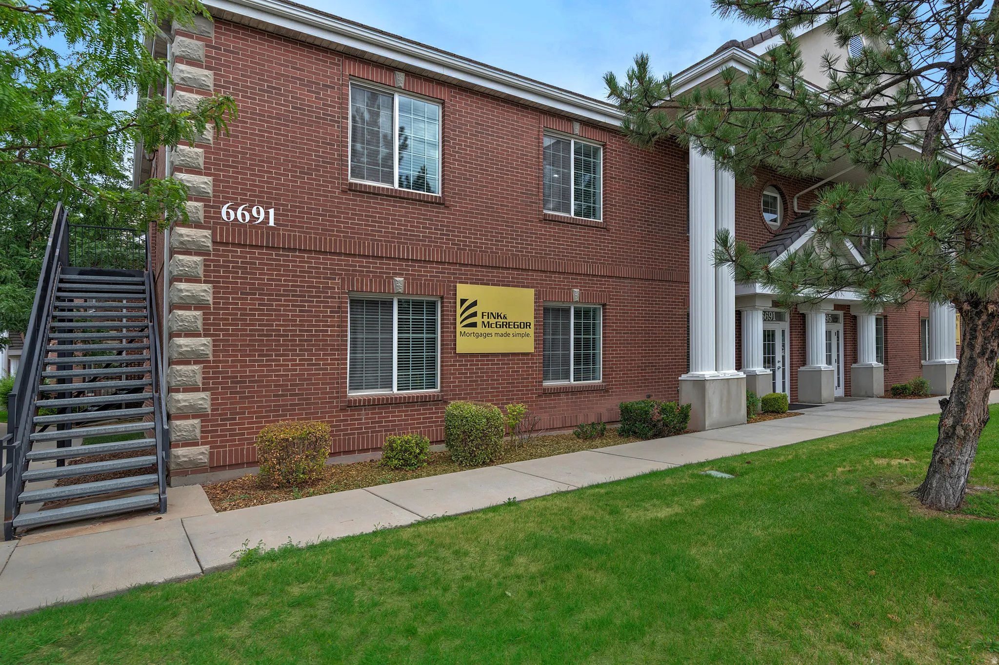 Brick exterior with stone accents and a prominent white columned entrance