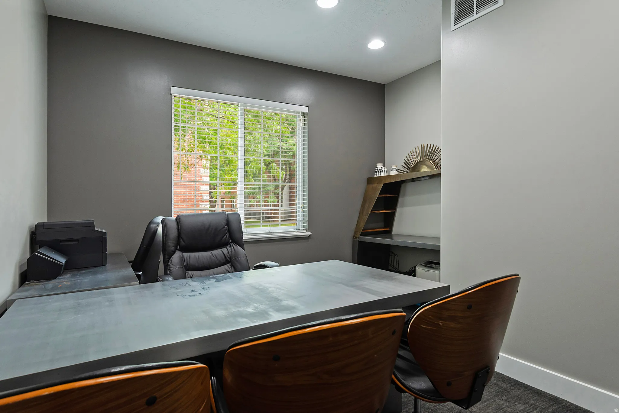 Dedicated room featuring recessed lighting, a built-in wood-finish shelving unit, a window with blinds, and two-tone wall finishes