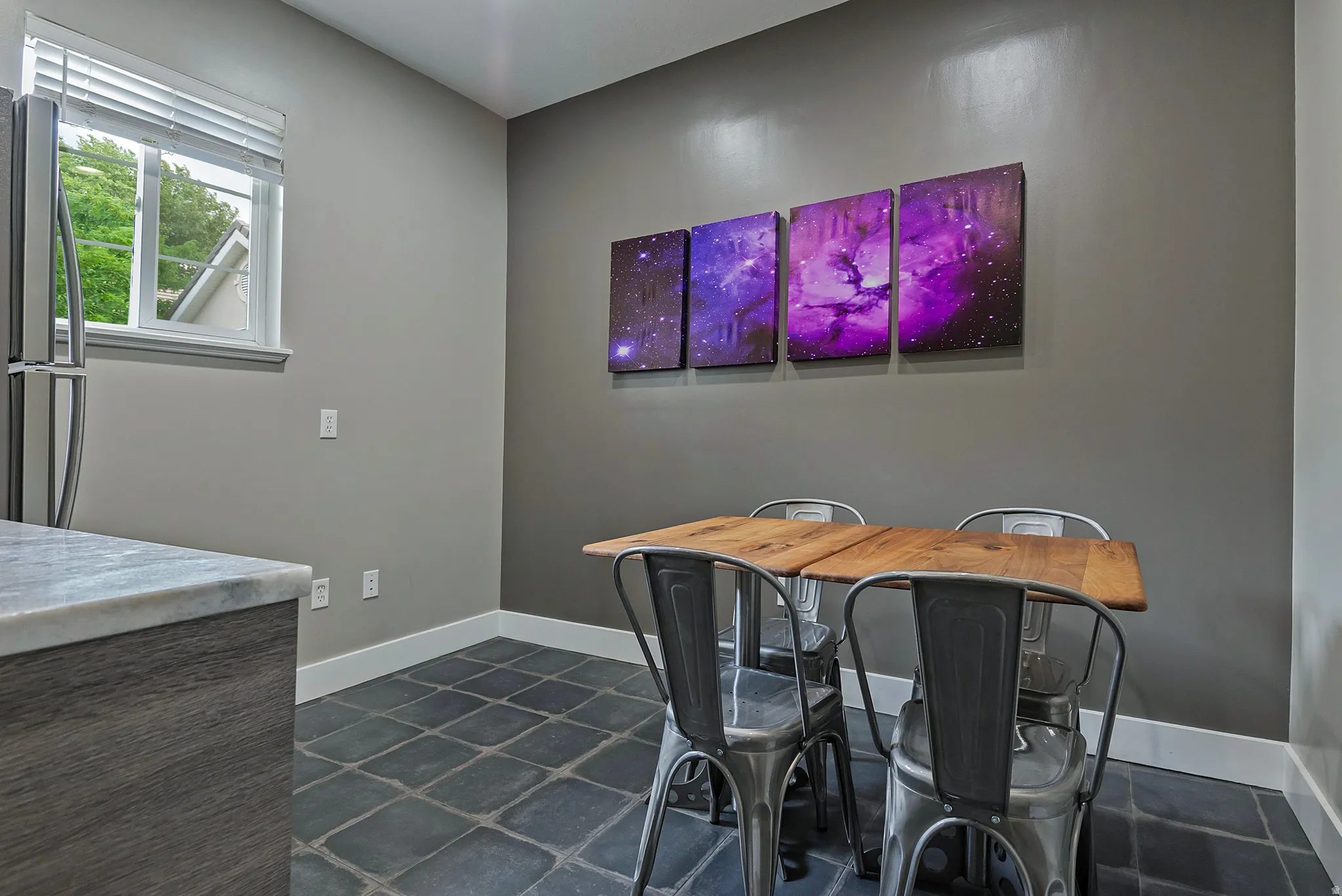 Kitchen dining area featuring stone tile flooring and white trim
