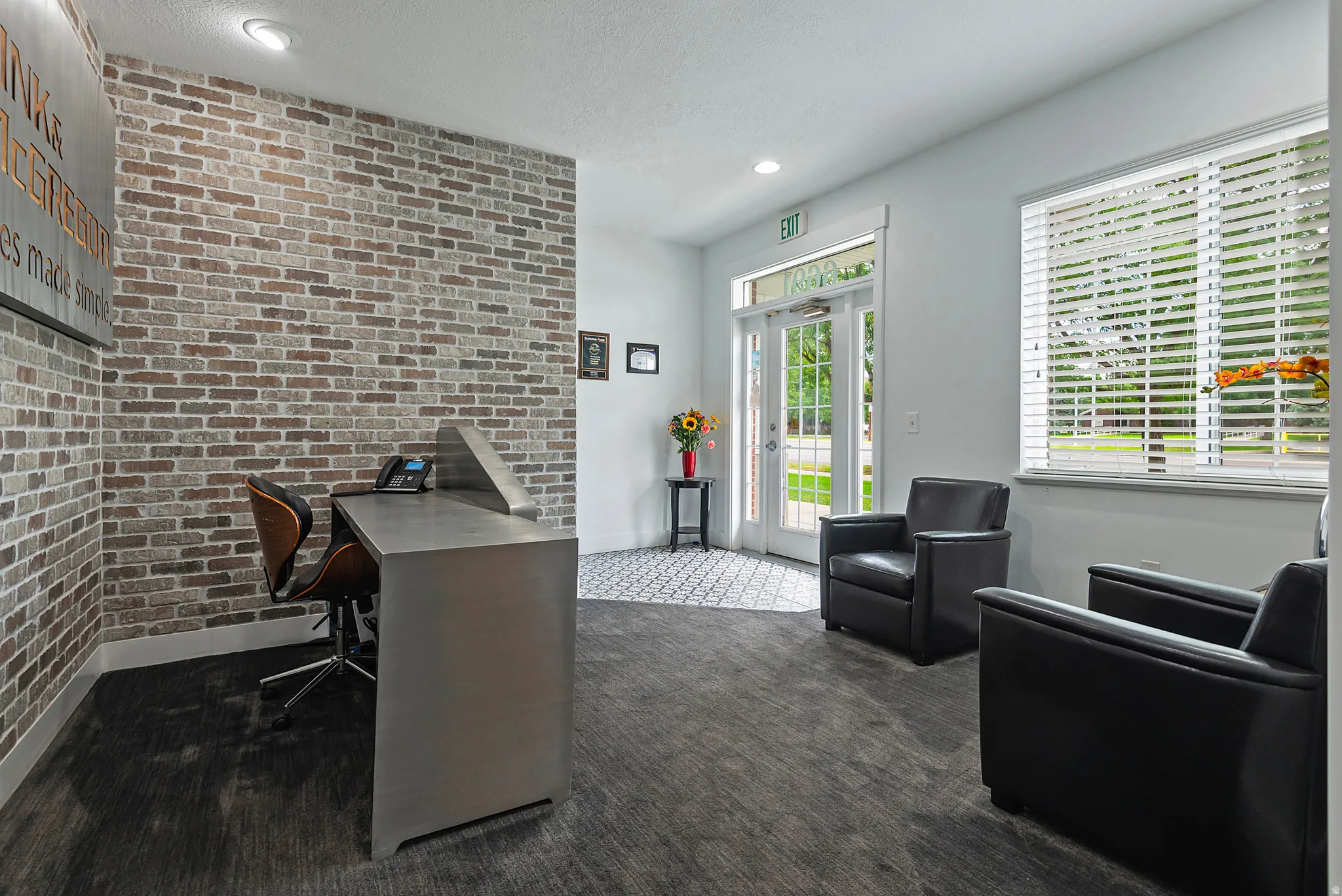 Entry area featuring a mixed-material brick wall accent, wood-finish flooring, and white trim