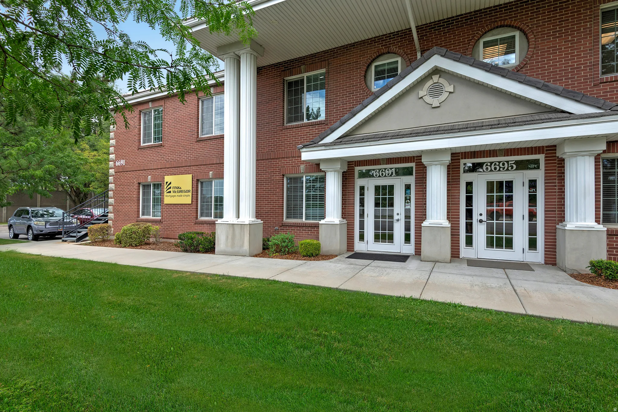 Brick exterior with white window frames and round accent windows