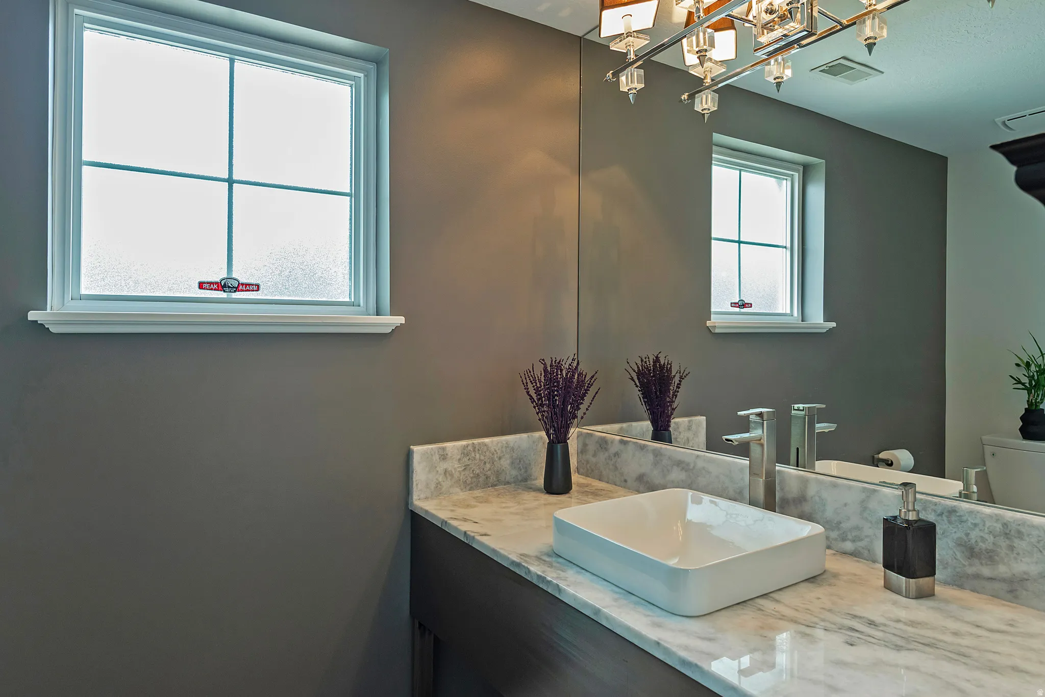Contemporary bathroom featuring a rectangular vessel sink, polished chrome fixtures, and a marbled countertop