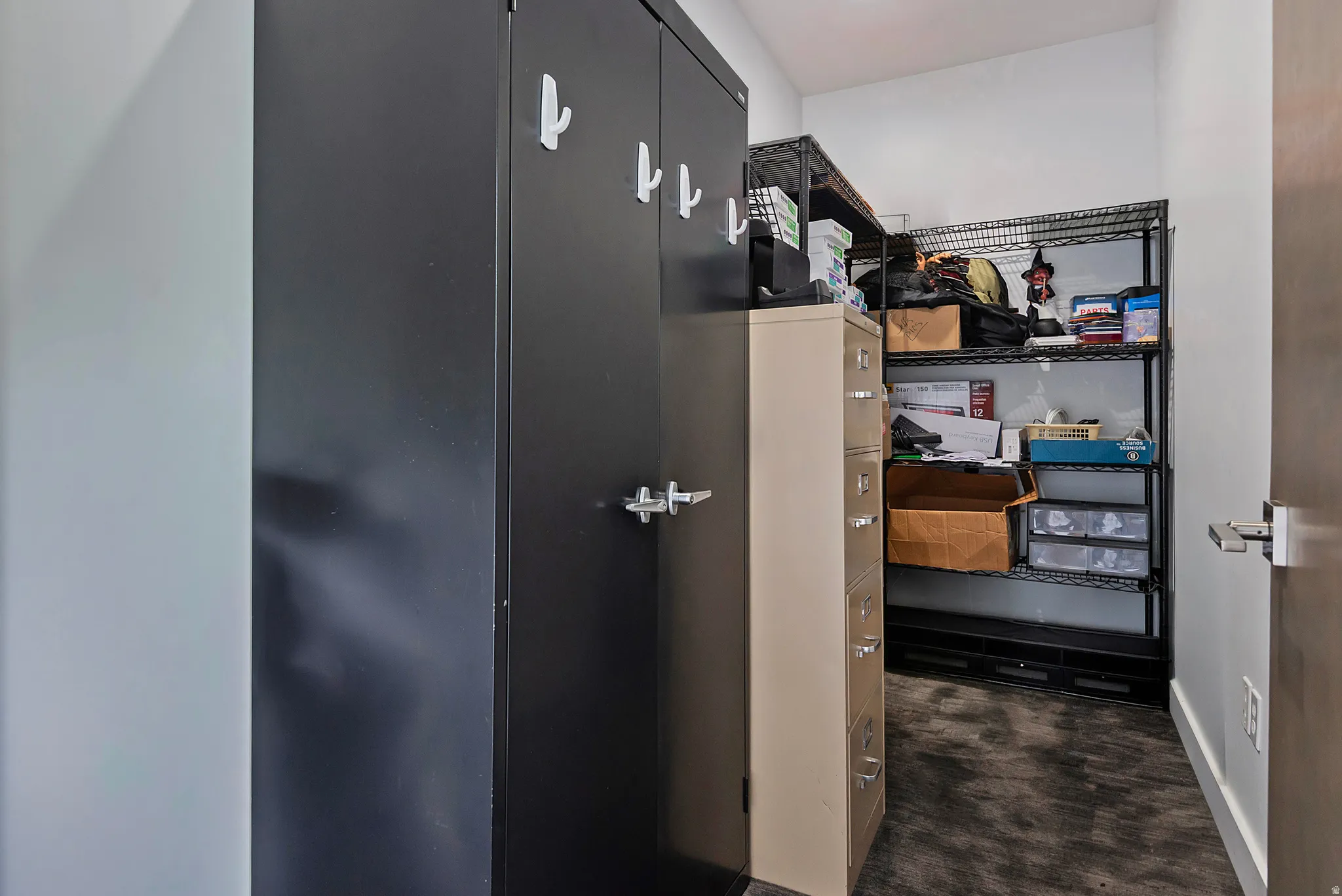 Black metal storage cabinet with integrated hooks and chrome handles
