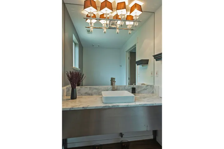 Bathroom vanity featuring a rectangular vessel sink, substantial countertop, and a full-width mirror