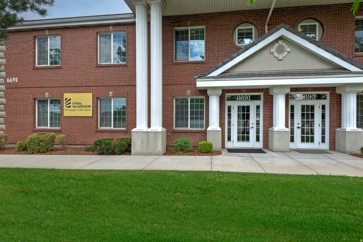 Brick exterior with white window frames and a prominent entry portico