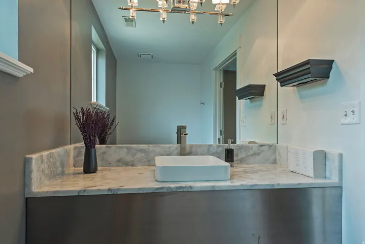 Contemporary bathroom vanity featuring a rectangular vessel sink, brushed nickel faucet, and a large wall-mounted mirror