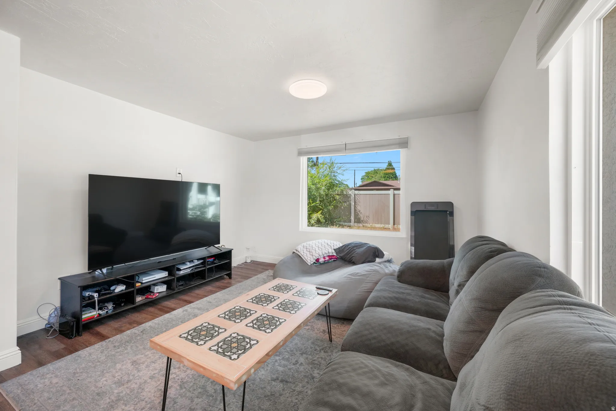 Spacious room with wood-finish flooring and neutral wall tones