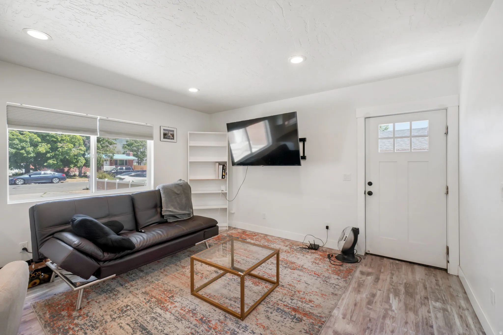Living area featuring wood-finish flooring, recessed lighting, and white walls