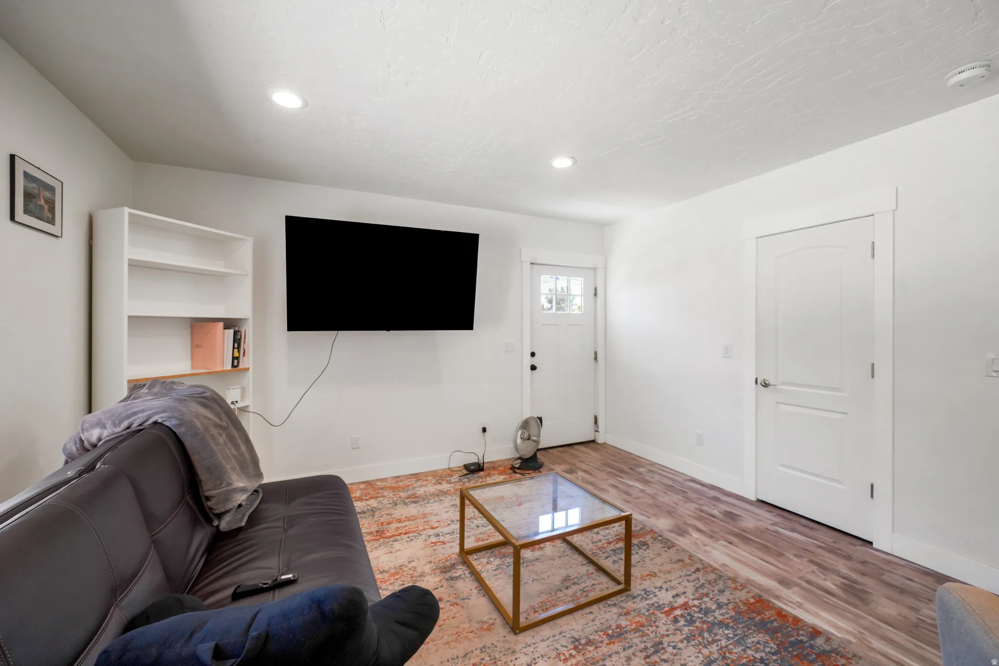 Bright living space featuring wood-finish flooring and recessed lighting
