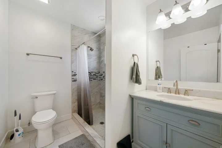 Bathroom featuring a single vanity with a light blue base, a light-colored countertop, and a rectangular mirror