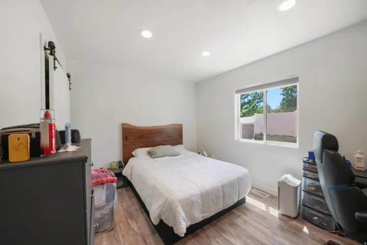 Bright room featuring wood-finish flooring, recessed lighting, and a barn door