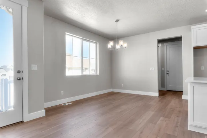 Open-concept area featuring wide-plank wood-finish flooring and neutral wall tones