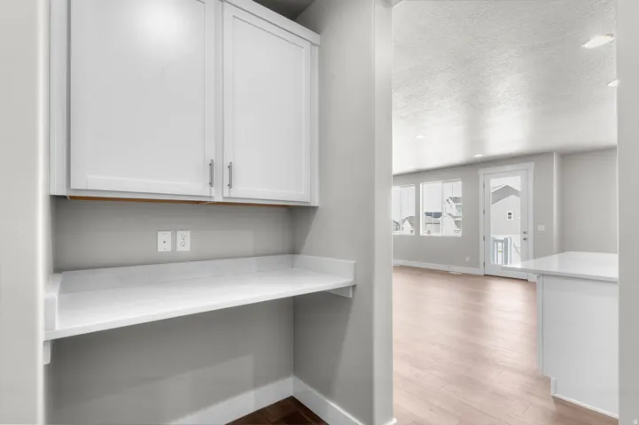 Built-in desk area featuring white shaker-style cabinetry, a light-toned countertop, and light gray wall paint
