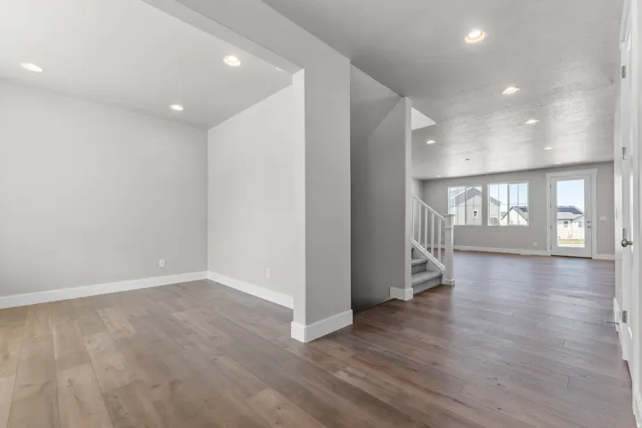 Open-concept living area featuring wood-finish flooring, recessed lighting, and light gray walls