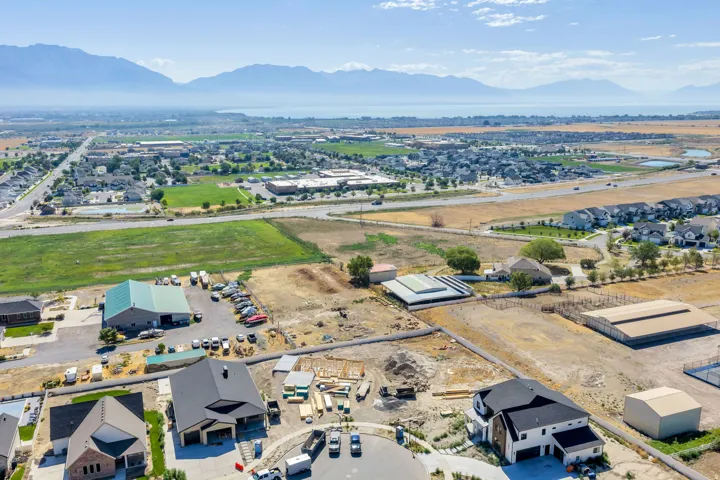 Expansive aerial landscape featuring a residential community, distant mountains, and a body of water
