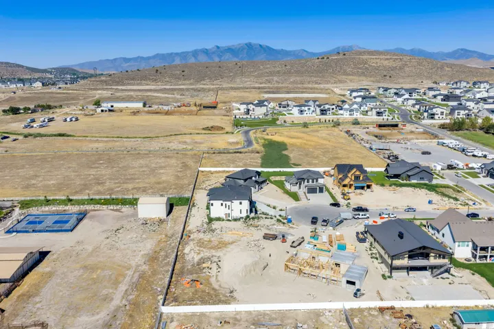Expansive aerial capturing a developing neighborhood with mountainous terrain in the background