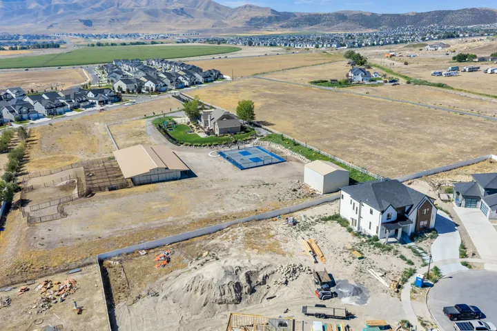 Expansive property featuring a large barn, fenced enclosures, and a sport court