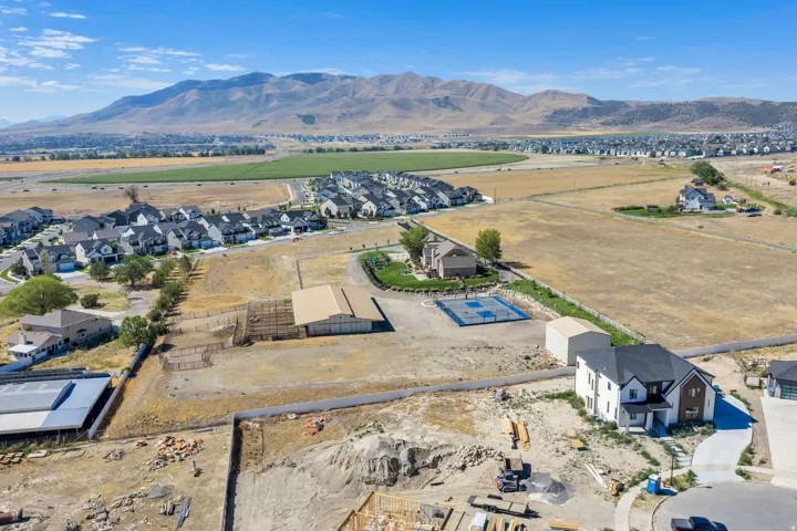 Expansive property featuring a large outbuilding, a sport court, and multiple residential structures