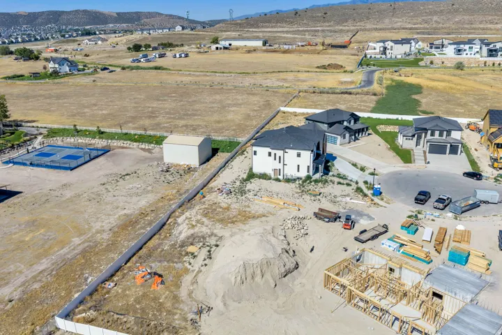 Expansive land parcel featuring existing residential structures, a tennis court, and a storage building