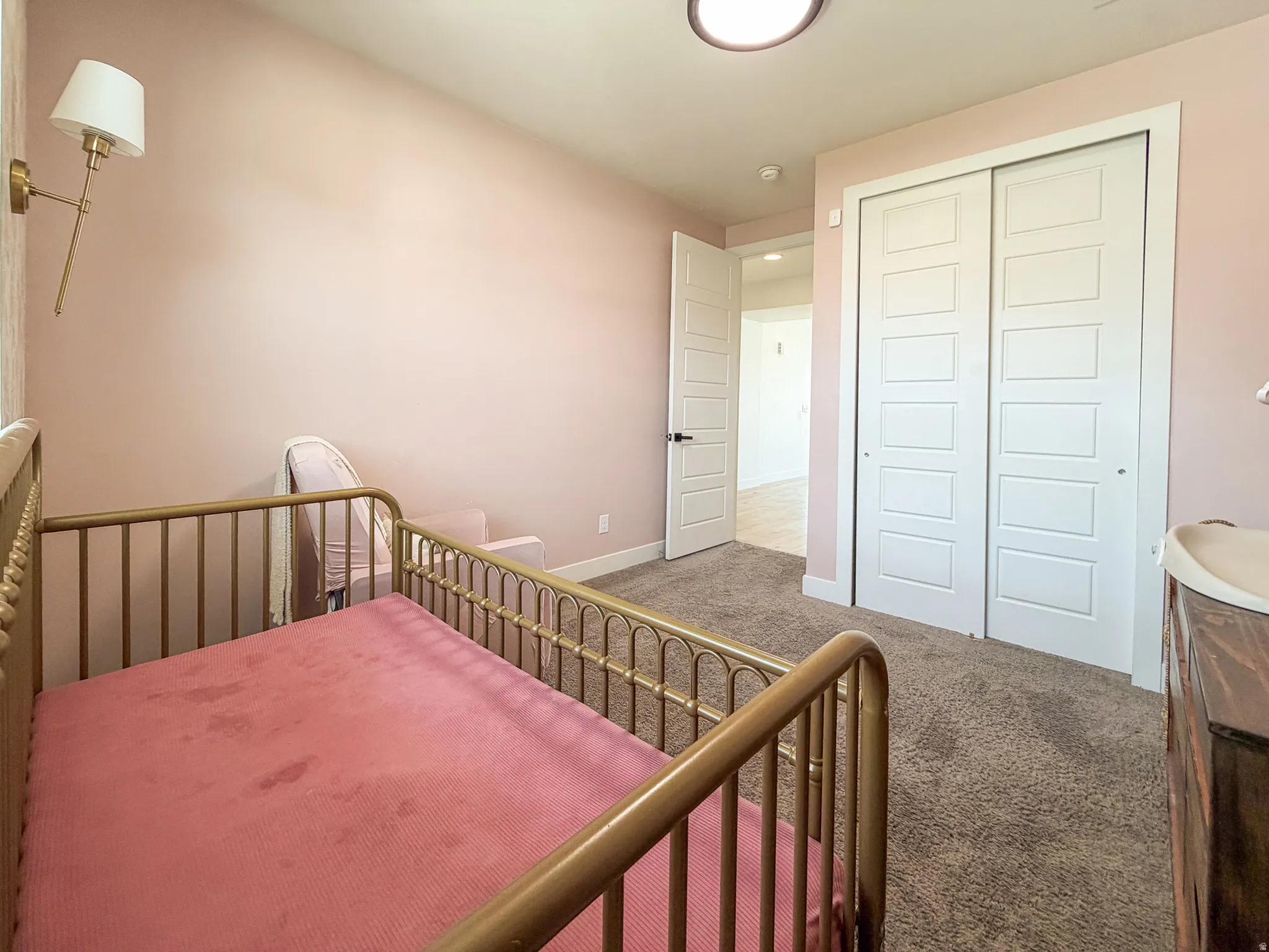 Recessed ceiling light fixture illuminating a room with soft pink walls