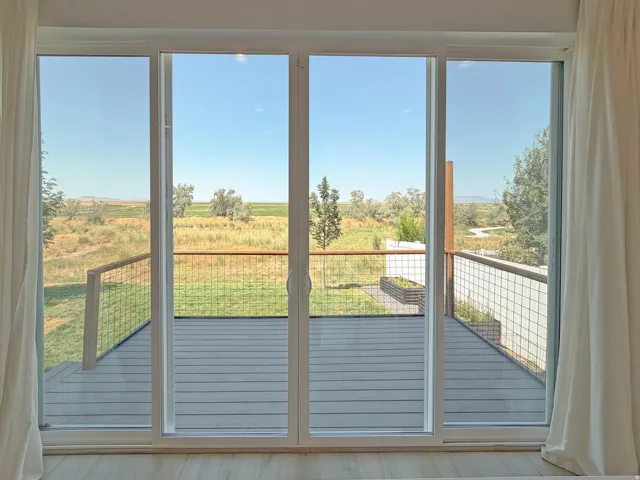Sliding glass doors opening to an exterior deck with wire railing