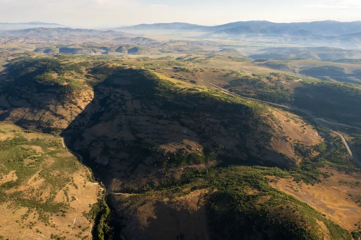 Expansive natural landscape featuring rolling hills and distant mountains