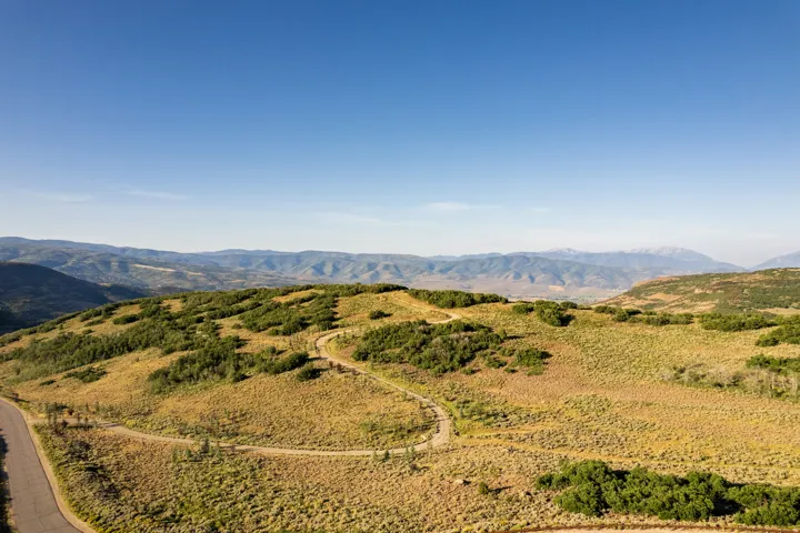 Expansive mountain landscape with clear blue skies and distant peaks