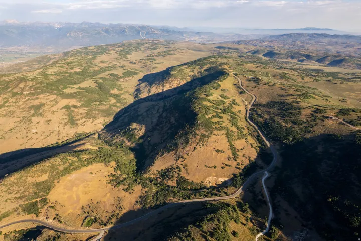 Sprawling mountainous landscape featuring winding roads and varied topography