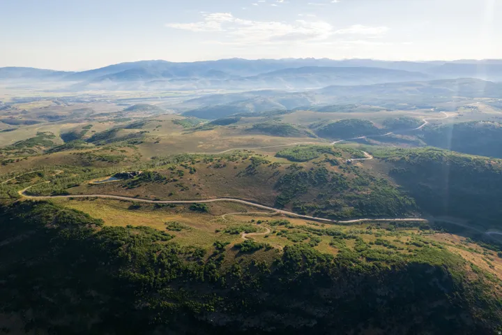 Expansive rural landscape featuring rolling hills and distant mountains