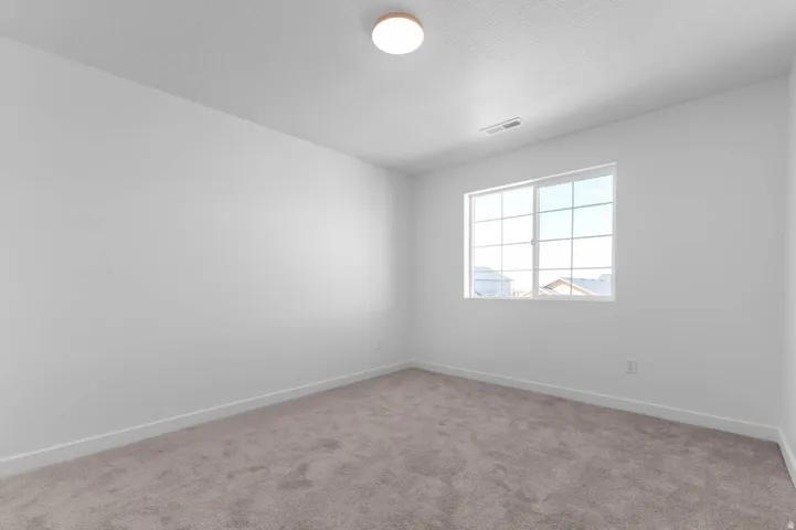 Neutral gray carpeting with white baseboards throughout