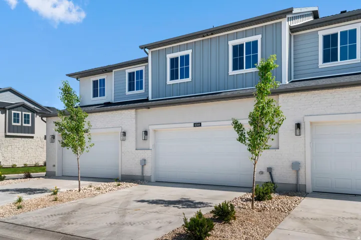 Modern townhome exterior featuring light brick and board-and-batten siding