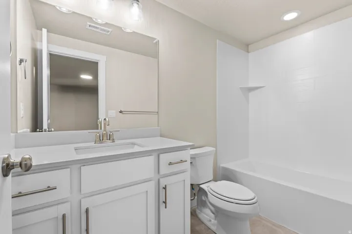 Spa-inspired bathroom featuring a white vanity with dual sink configuration, brushed nickel hardware, and ample counter space