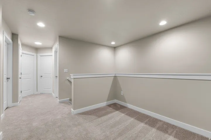 Carpeted bonus room featuring recessed lighting, chair rail molding, and a neutral color palette