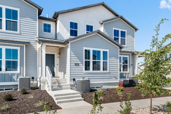 Contemporary townhouse exterior featuring light blue horizontal siding and white trim