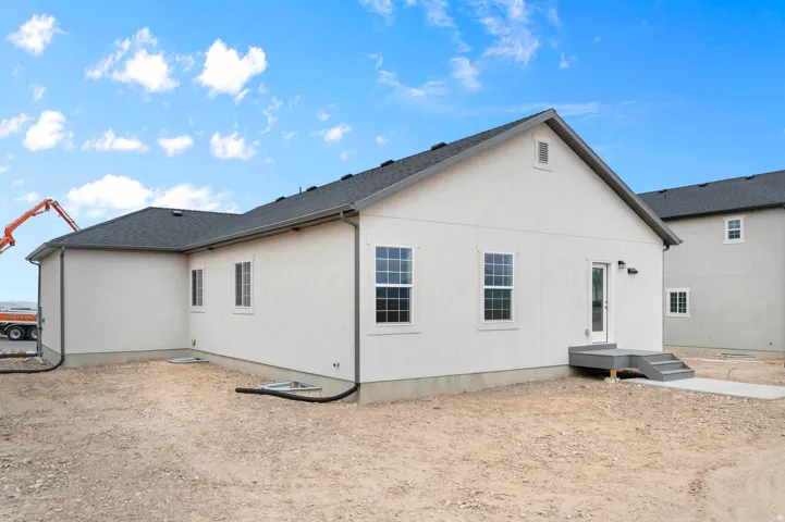Stucco exterior featuring multiple windows with gray trim