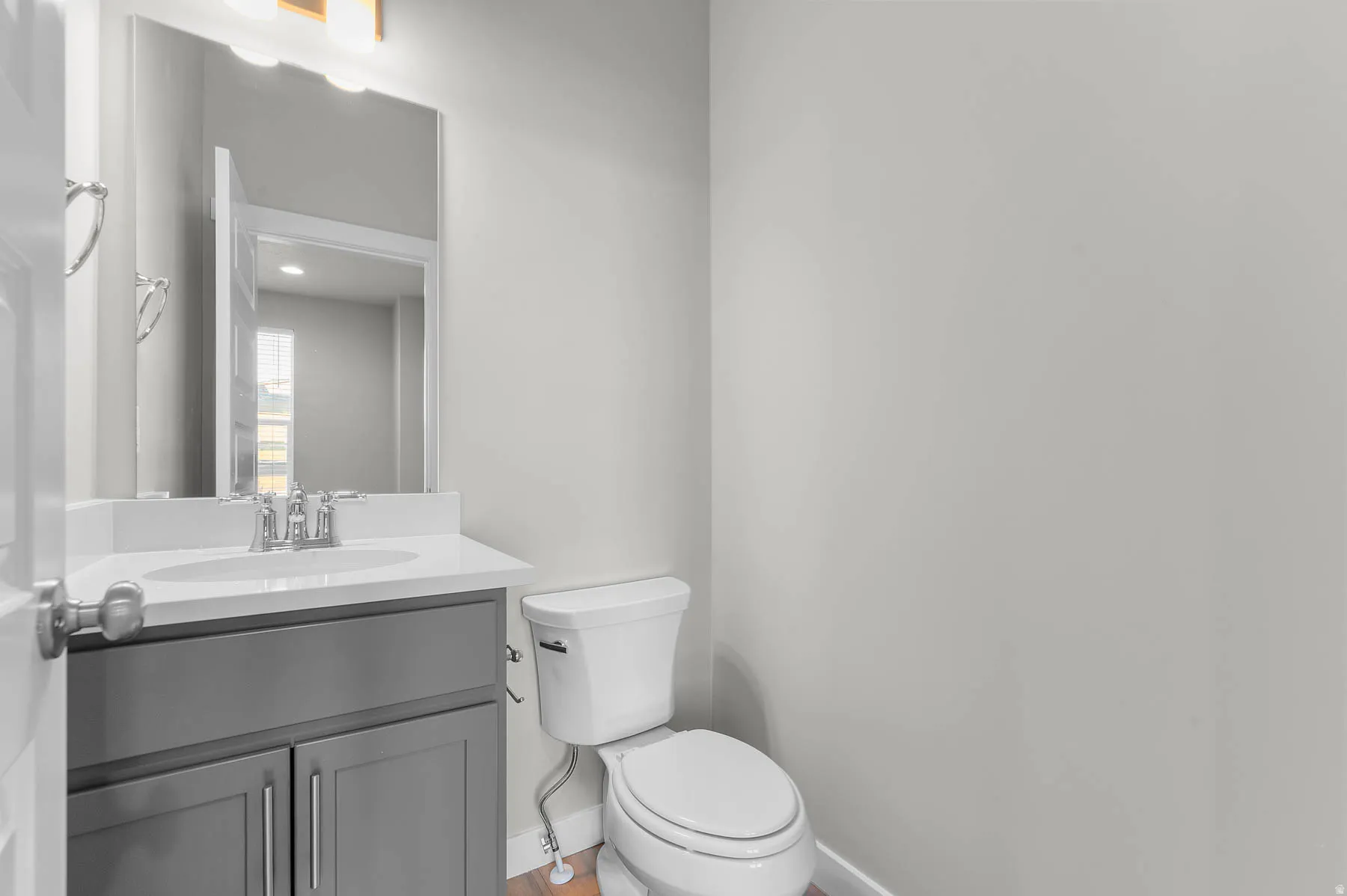 Powder room featuring a single vanity with gray cabinetry, white countertop, and a rectangular undermount sink