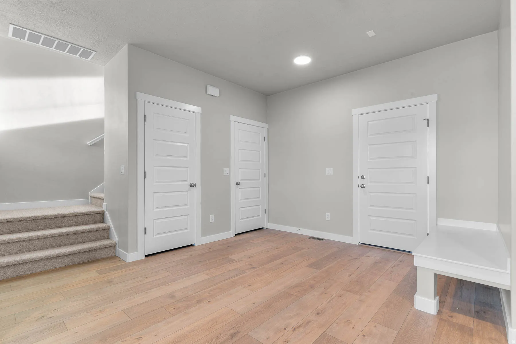 Light wood-finish flooring complements the neutral wall tones