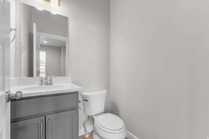 Powder room featuring a single vanity with gray cabinetry, white countertop, and a rectangular undermount sink