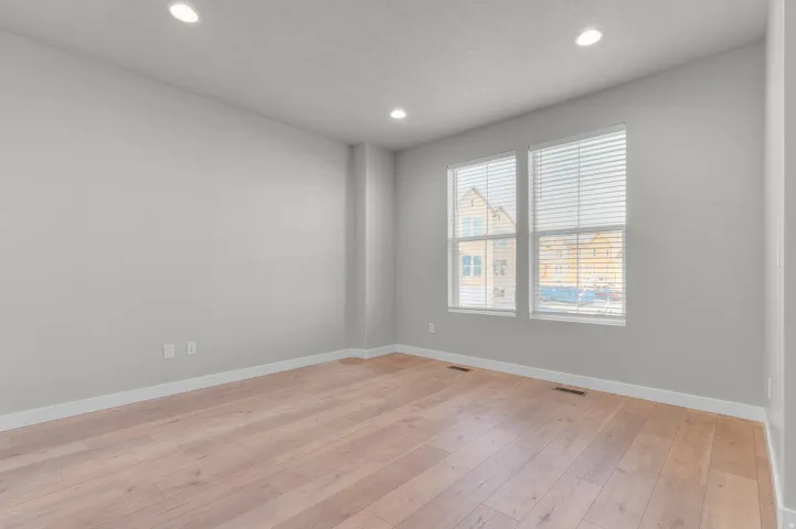 Light-toned wood-finish flooring complements the neutral wall color