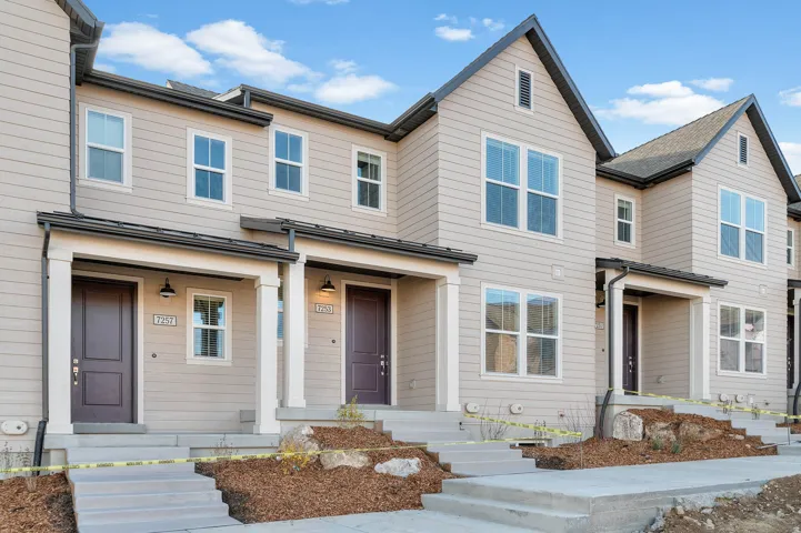 Contemporary townhome exteriors featuring neutral siding, prominent gables, and dark trim