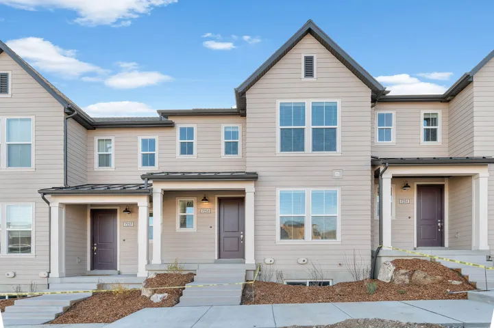 Modern townhome facade featuring light-colored siding and dark trim accents